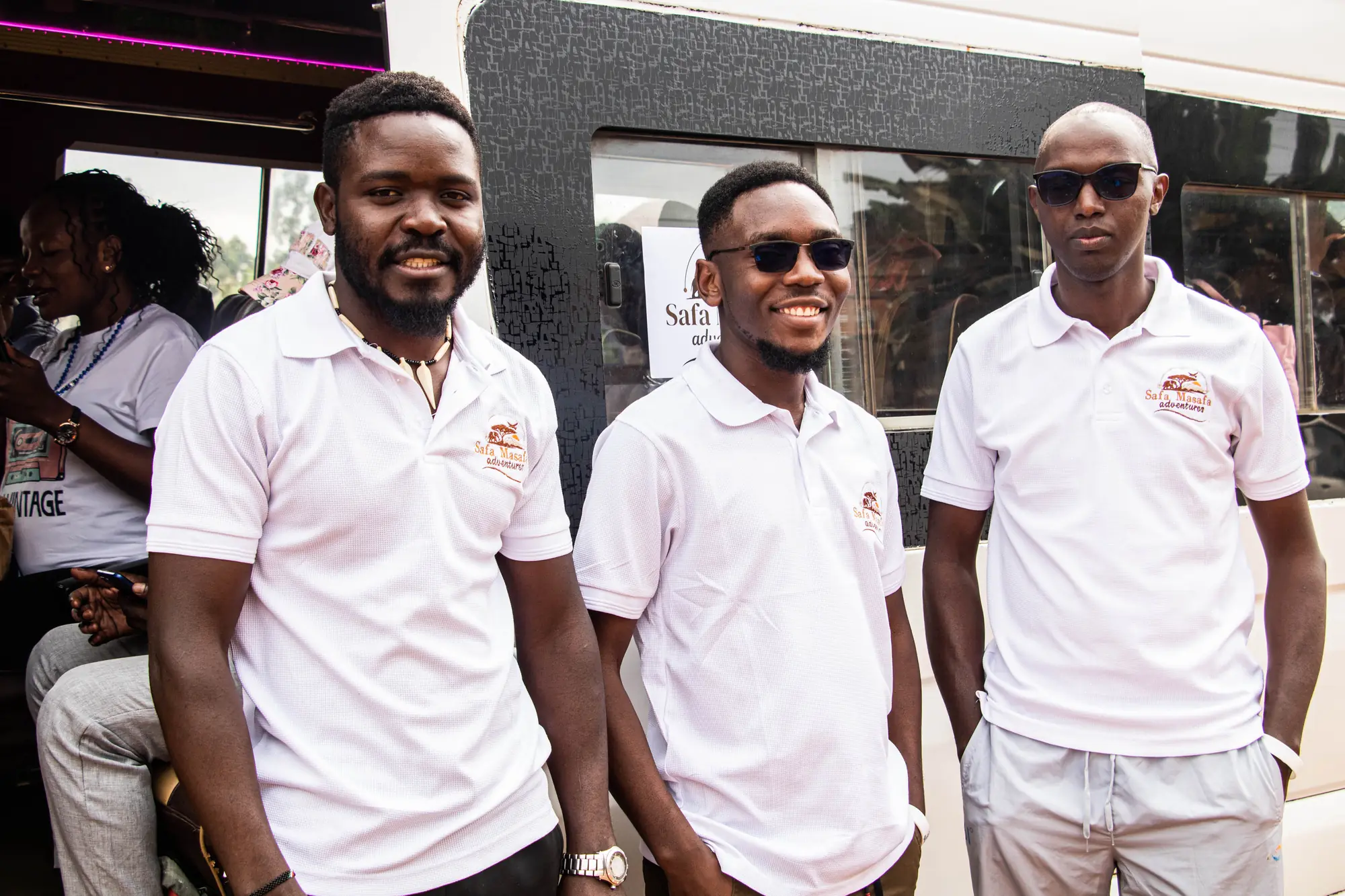 The Safa Masafa crew in branded polos beside the tour bus